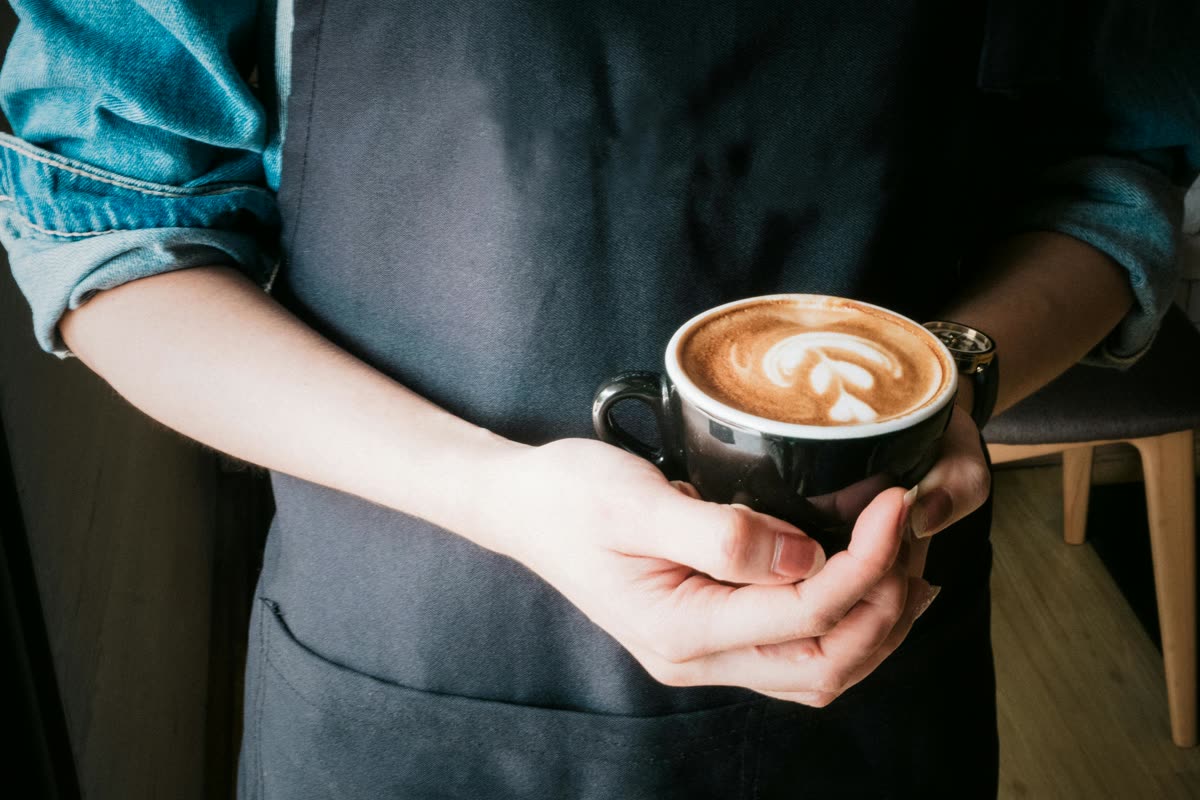 Barista bereidt specialty koffie met latte art
